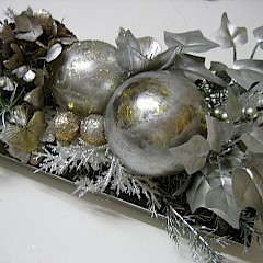 Mooi zilverkleurig kerststuk op metalen schaaltje.
